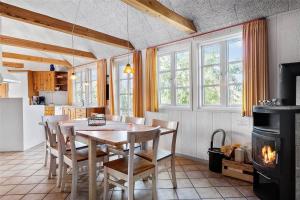 a kitchen with a table and chairs and a fireplace at 0227-Romo-Kromosevej-17 in Høm +16 photos
