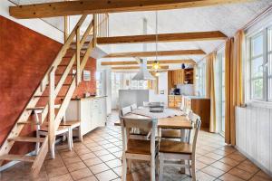 a kitchen and dining room with a wooden table and stairs at 0227-Romo-Kromosevej-17 in Høm