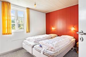 two beds in a room with red walls at 0227-Romo-Kromosevej-17 in Høm