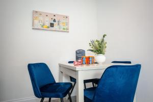 two blue chairs sitting next to a white table at Limefield Residence in West Calder +10 photos