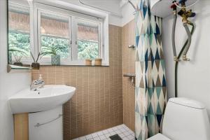 a bathroom with a sink and a toilet and a window at 0172-Romo-Rabjergvej-84 in Høm +15 photos