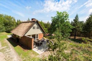 a small house with a thatch roof on a field at 0172-Romo-Rabjergvej-84 in Høm