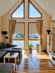 a living room with two couches and two windows at Ferienwohnung Am Korretsberg in Kruft