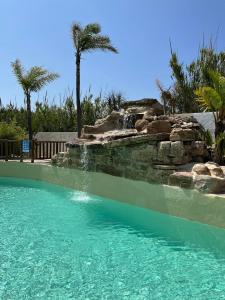 ein Schwimmbad mit Wasserfall in einem Ferienresort in der Unterkunft Hotel La Torre in Tarifa + 57 Fotos