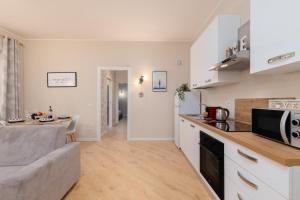Eine Küche und ein Wohnzimmer mit Sofa und Mikrowelle in der Unterkunft Vicolo 6 in Bollate