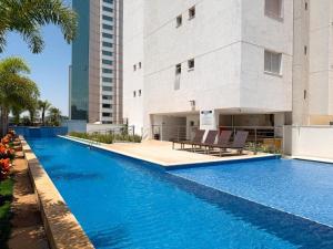 a swimming pool in front of a building at Flat Lounge 22 Setor Oeste in Goiânia