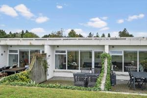 a white house with a table and chairs at 0263-Romo-Lyngvejen-99-Ap-28 in Høm