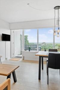 a dining room with a table and a large window at 0263-Romo-Lyngvejen-99-Ap-28 in Høm