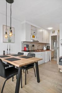 a kitchen and dining room with a wooden table and chairs at 0263-Romo-Lyngvejen-99-Ap-28 in Høm +16 photos