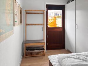 a bedroom with a bed and a wooden door at 0263-Romo-Lyngvejen-99-Ap-28 in Høm