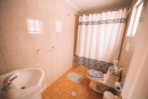 a small bathroom with a toilet and a shower at Vientos San Pedro in San Pedro de Atacama +61 photos