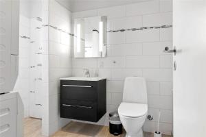 a white bathroom with a toilet and a sink at 0347-Romo-Vestergade-353 in Høm +13 photos