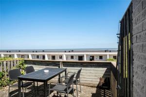 a table and chairs on a balcony with a view of the ocean at 0265-Romo-Lyngvejen-99-Ap-18 in Høm