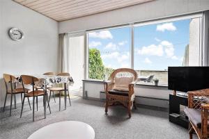 a living room with a table and chairs and a large window at 0265-Romo-Lyngvejen-99-Ap-18 in Høm