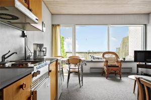 a kitchen with a table and chairs and a large window at 0265-Romo-Lyngvejen-99-Ap-18 in Høm