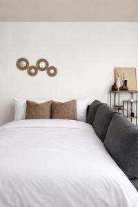 a bedroom with a large white bed with brown pillows at Au Petit Colombage - Cosy au centre de Mulhouse - Gare proche in Mulhouse