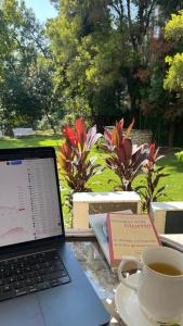 a laptop computer sitting on a table with a cup of coffee at Boutique Villa w Bonfire & BBQ, Mussoorie Foothills in Dehradun