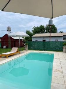 a large swimming pool with an umbrella and anractor at Complejo Juan Pablo in Colón