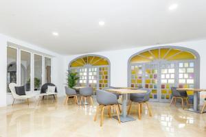a dining room with tables and chairs and windows at BLUESEA Rey Carlos in Playa del Ingles