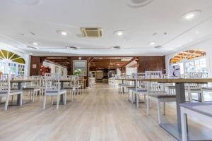 a dining room with tables and white chairs at BLUESEA Rey Carlos in Playa del Ingles