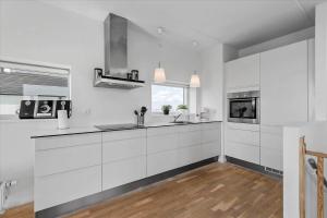 a white kitchen with a sink and a microwave at 0277-Romo-Hollaenderstraedet-38 in Høm +11 photos