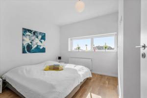 a white bedroom with a bed and a window at 0277-Romo-Hollaenderstraedet-38 in Høm