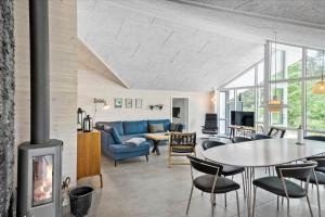 a living room with a fireplace and a blue couch at 0308-Romo-Vagtelvej-4 in Høm