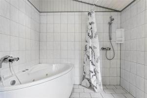 a white bathroom with a tub and a shower at 0240-Romo-Peder-Jespersensvej-9 in Høm +11 photos