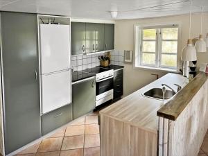 a kitchen with green cabinets and a white refrigerator at 0339-Romo-A-Hveyselsvej-32 in Høm +28 photos