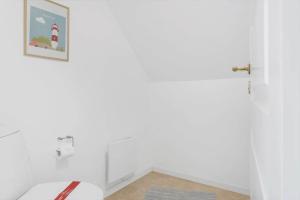 a bathroom with a toilet and a picture on the wall at 0339-Romo-A-Hveyselsvej-32 in Høm