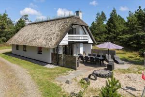 a house with a thatched roof with a patio at 0339-Romo-A-Hveyselsvej-32 in Høm
