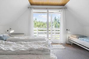 a bedroom with two beds and a large window at 0339-Romo-A-Hveyselsvej-32 in Høm