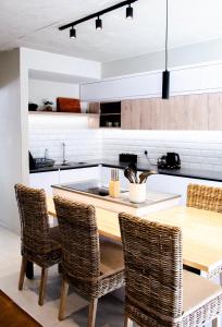 a kitchen with a wooden table and rattan chairs at Rustic Hills No 3 Self Catering in Swakopmund +7 photos