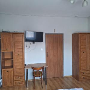 a room with a table and some wooden cabinets at Noclegi Arka in Osiek