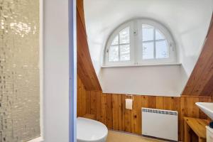 an attic bathroom with a toilet and a window at 0162-Romo-Rabjergvej-97 in Høm