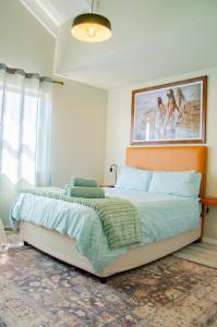 a bedroom with a bed and a painting on the wall at Rustic Hills No 3 Self Catering in Swakopmund