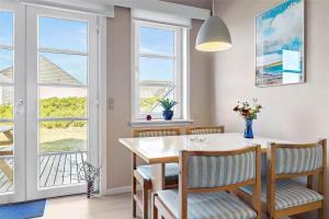 a dining room with a table and chairs and windows at 0432-Romo-Vestergade-225-App-7 in Høm