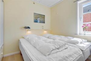 a group of white pillows on a bed in a room at 0432-Romo-Vestergade-225-App-7 in Høm +25 photos