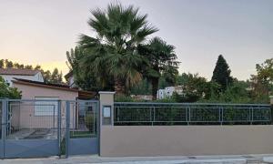 a house with a gate and a palm tree at Galini Home 2 in Prokópion