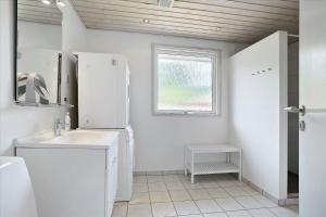 a white bathroom with a sink and a window at 0424-Romo-Sonderstrandvej-15 in Høm +16 photos