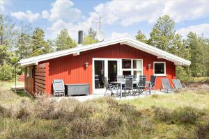 a red house with chairs and a table in front of it at 0424-Romo-Sonderstrandvej-15 in Høm