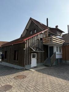 a large wooden building with a porch and a door at Gästehaus Eichberg, Rheintal in Eichberg