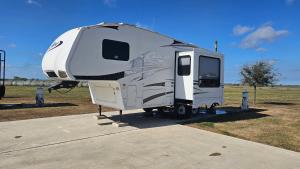 a white rv parked in a field at Starry Skies RV in Victoria
