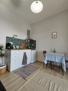 a kitchen with white cabinets and a table in a room at SEA VIEW in Nea Skioni