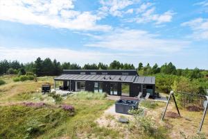 a house with a black roof in a field at 0226-Romo-A-M-Listsvej-4 in Høm