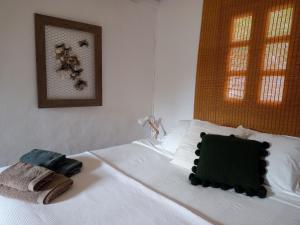 a bedroom with a white bed with two towels on it at Residence Can Confort Formentera in Sant Francesc Xavier