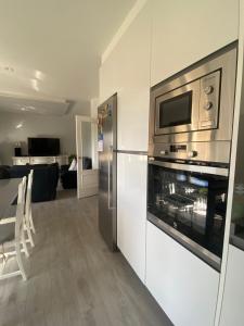 a kitchen with a stainless steel refrigerator and a microwave at Chalet Bordones Playa in Bordons +13 photos