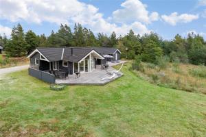 a small house on a large grassy field at 0195-Romo-Smafolksvej-65 in Høm