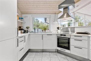 a white kitchen with white cabinets and a window at 0195-Romo-Smafolksvej-65 in Høm