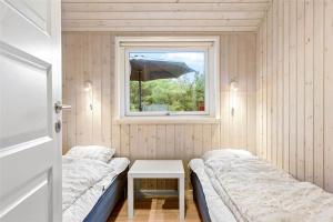 a small room with two beds and a window at 0195-Romo-Smafolksvej-65 in Høm